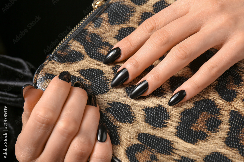 Woman with professional manicure holding leather bag, closeup