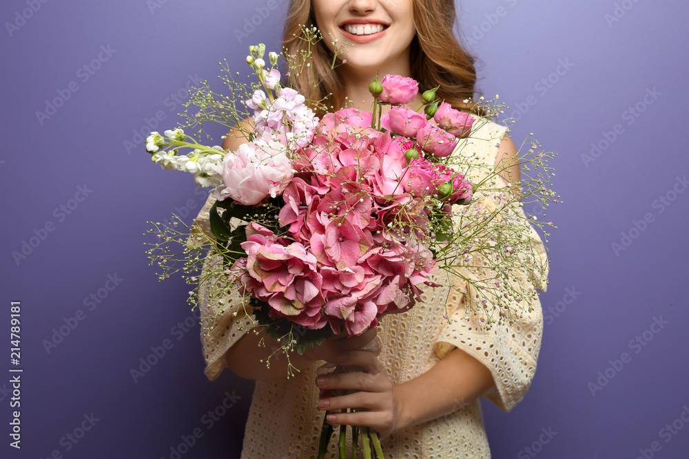 Young woman with beautiful flowers on color background