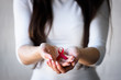 © lordn - Woman holding red ribbon on her palms. AIDS awareness symbol