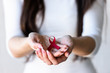 © lordn - Woman holding red ribbon on her palms. AIDS awareness symbol
