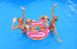 © Brigitte - Two girls wearing bikinis gather around an  inflatable swim ring. Two young twin sisters  sit on the swim ring. They all are having some summer pool fun.