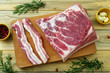 carne di maiale cruda costolette e petto su tagliere di legno