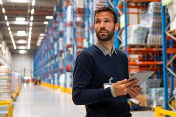 Poster - Manager in warehouse holding digital tablet