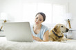 © Jessica Peterson/Tetra Images - Woman using laptop with dog