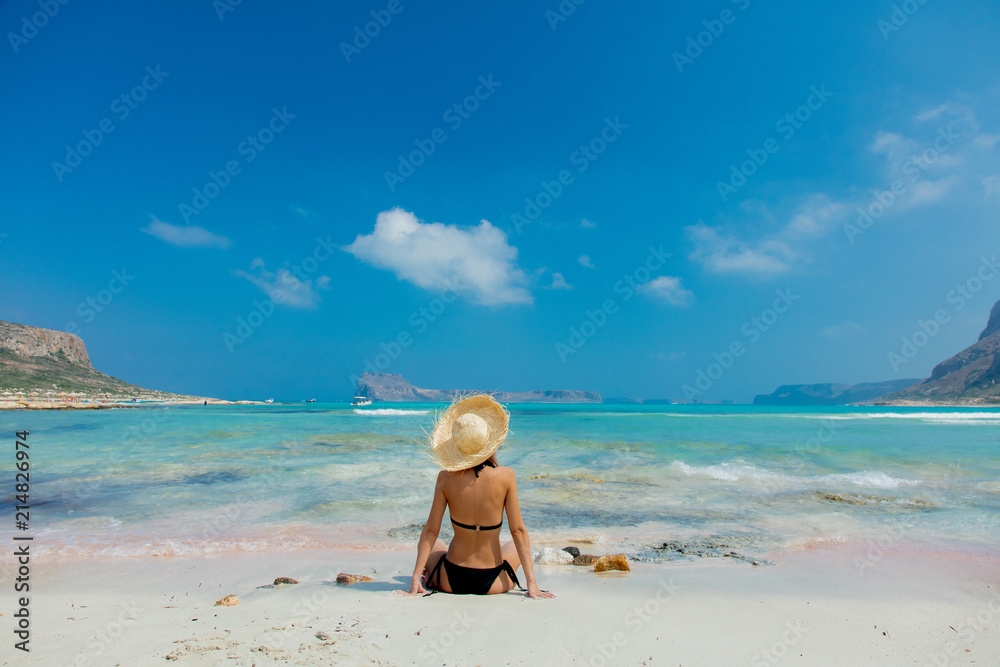 Obraz na płótnie Young redhead girl in black bikini and with hat on Balos beach, west Crete, Greece. Summertime season vacation, July w salonie