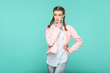 © khosrork - confused thinking portrait of beautiful cute girl standing with makeup and brown pigtail hairstyle in striped light blue shirt pink jacket. indoor, studio shot isolated on blue or green background.