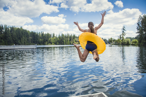 Fototapety skoki do wody  mala-dziewczynka-skaczac-ze-stacji-dokujacej-do-pieknego-gorskiego-jeziora-zabawa-latem
