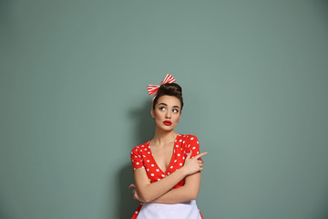 Poster - Portrait of funny young housewife on color background