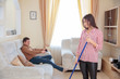 © Aleksei Lazukov - happy husband watching TV, offended wife standing with a mop