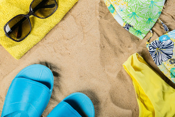 Summer concept - bathing suit, sunglasses, flip flops, towel