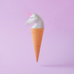 Wall Mural - white painted unicorn head ice cream on pastel purple background. minimal art fantasy concept. summe