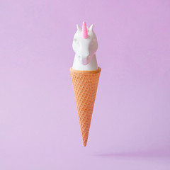 Wall Mural - white painted unicorn head ice cream on pastel purple background. minimal art fantasy concept. summe
