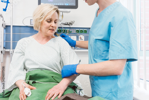 Nurse Caring For Patient In Recovery Room Of Hospital