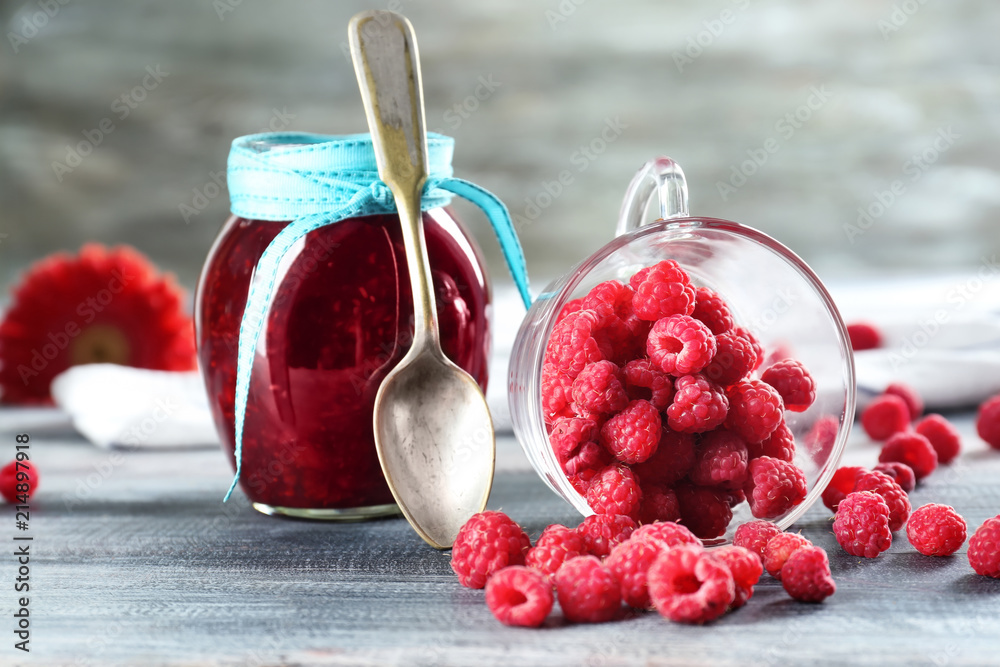 Composition with tasty jam and raspberries on wooden table