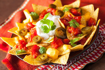 Wall Mural - nachos loaded with salsa, cheese and jalapeno