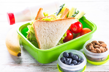 Wall Mural - Lunch box with sandwich, vegetables, banana, water, nuts and ber