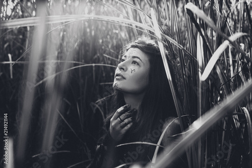 Plakat Beautiful young woman model with very long hair outdoors on a field. Black and white