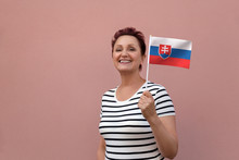 Slovakia Flag. Woman Holding Slovakian Flag. Nice Portrait Of Middle Aged Lady 40 50 Years Old With A National Flag Over Pink Wall Background.