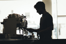 Silhouette Of Barista Preparing Coffee In A Coffee Bar
