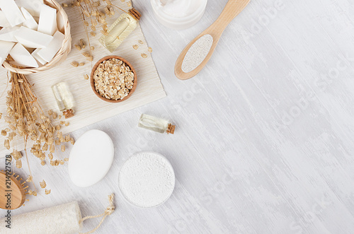 Fotomural Organic homemade white cosmetics and raw oatmeal flakes, massage oil, bath accessories on light beige wooden background, flat lay