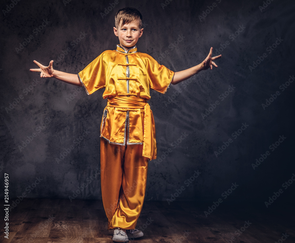 Cute boy dressed in the traditional costume of a Tibetan monk shows the tricks from the wellness complex at the studio.
