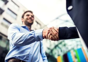 A young businessman and businesswoman shaking hands.