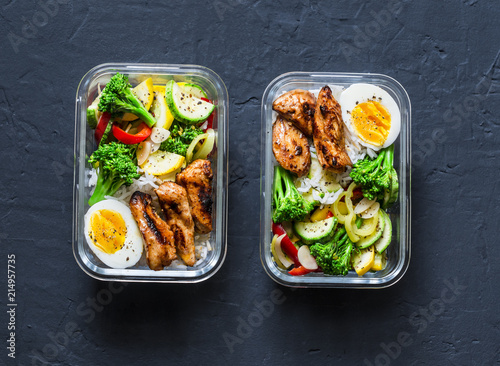 Fotomural Rice, stewed vegetables, egg, teriyaki chicken - healthy balanced lunch box on a dark background, top view
