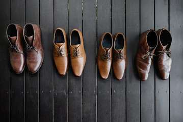 Men's leather brown shoes on the black lath wooden floor