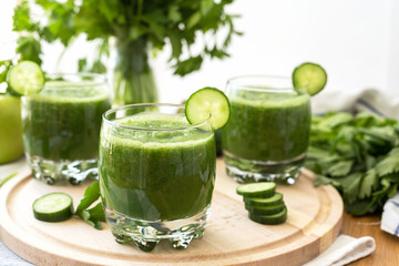 Wall Mural - Fresh green smoothies with parsley, spinach, cucumber, lime in a glass on a  wooden board. Healthy food. Detox. 