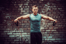 Fitness Man Exercising With Stretching Band. Muscular Sports Man Exercising With Elastic Rubber Band. Guy Working Out With Rubber Band. Fit, Fitness, Exercise, Workout And Healthy Lifestyle