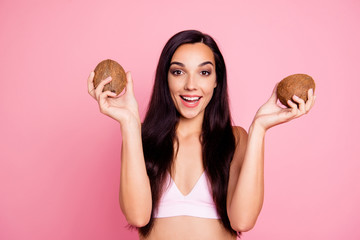 Lifestyle leisure concept. Close up studio photo portrait of pretty attractive charming cute lovely lady holding two coconuts in hands isolated on pastel bright vivid background