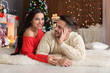 © New Africa - Happy young couple lying on floor at home. Christmas celebration