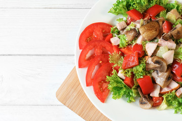 Plate with delicious fresh salad on table, top view