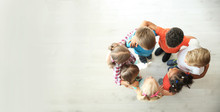 Little Children Making Circle With Hands Around Each Other Indoors, Top View. Unity Concept
