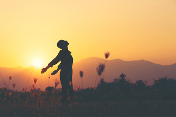 Freedom and sucess - woman happy at meadow . Free cheering girl with arms raised enjoying serene sunset in winning pose with arms stretched.