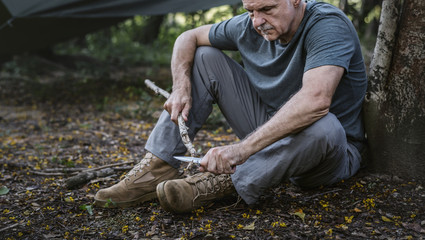 Mature man cutting some firewood