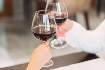 Wall Mural - Beautiful young couple with glasses of red wine in luxury restaurant