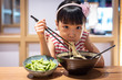 Leinwandbild Motiv Asian little Chinese girl eating ramen noodles