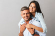 © Drobot Dean - Portrait of beautiful couple man and woman in basic clothing smiling and hugging together, isolated over gray background