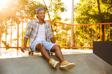 Poster - Happy young african man with skateboard