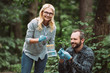 © LIGHTFIELD STUDIOS - selective focus of male and female scientists examining and taking sample of dry leaf in forest