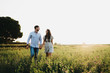 © ADDICTIVE STOCK - Couple walking on sunny field