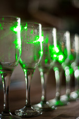 Blur abstract background interior of dark brown bar. Empty glasses for wine above a bar rack. Classic bar counter with bottles in blurred background. Interior of pub or bar at night. Luxury restaurant