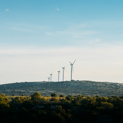 concept idea eco power energy. wind turbine on hill with sunset