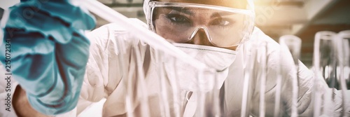 Fotomural Close up of a protected science student dropping liquid in a
