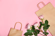 © New Africa - Stylish flat lay composition with shopping bags and flowers on color background
