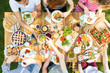 Top view on table with pizza, pastry and fruits. People eating lunch during outdoor party