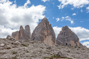 View towards the tops of the Tre Cime di Lavaredo with two mountaineers underneath, Dolomites, Italy