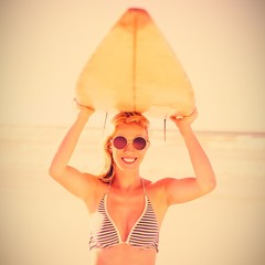 Poster - Portrait of young woman carrying surfboard at beach