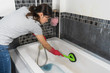 © geargodz - woman cleaning bathtub with brush